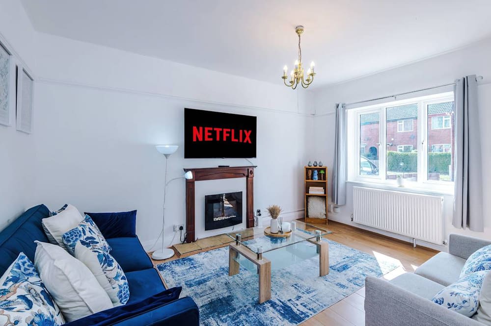 Living room of the Heworth house with fireplace and blue sofas